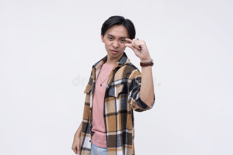 A cocky young man taunting you saying you have a minute chance of beating him. Gesturing with finger and thumb expressing royalty free stock images
