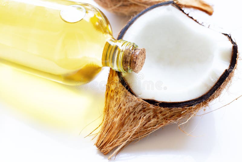Coconut oil with coconuts on white. 