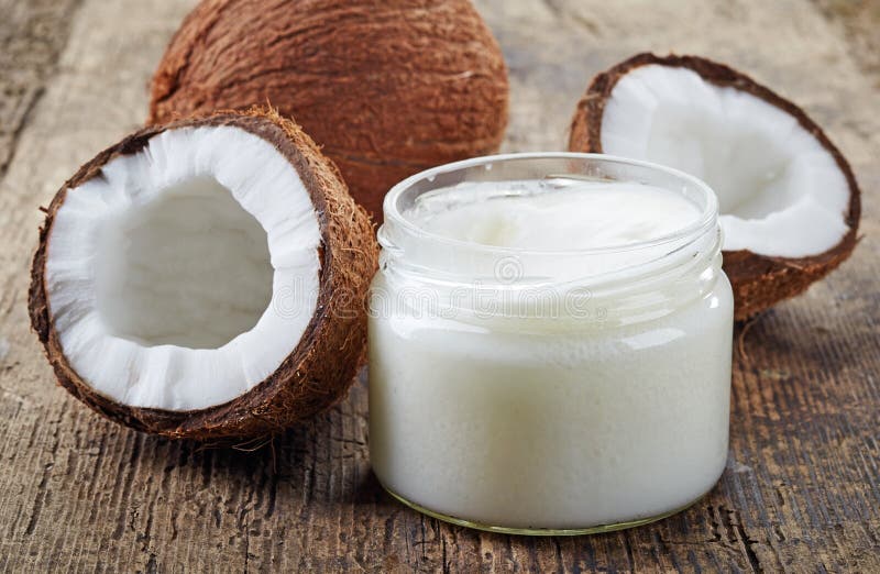 L'olio di cocco e noci di cocco fresche sul vecchio tavolo di legno.