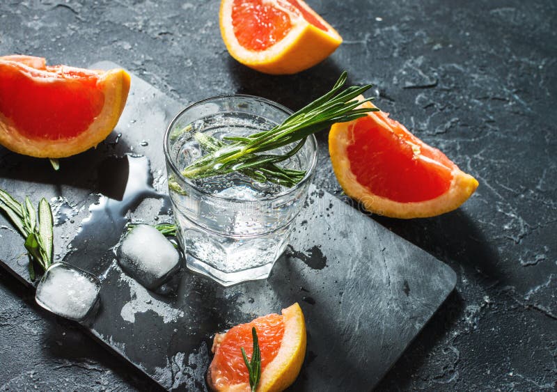 Coctail med grapefrukten, is och rosmarin på mörk stenbakgrund fotografering för bildbyråer Coctail med grapefrukten, is och rosmarin på mörk stenbakgrund fotografering för bildbyråer