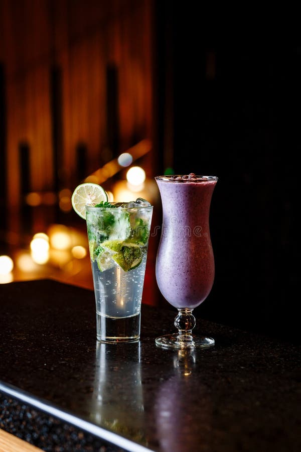 Coctailar p? den svarta tabellen - mojito- och b?rsmoothie royaltyfria foton Coctailar p? den svarta tabellen - mojito- och b?rsmoothie royaltyfria foton