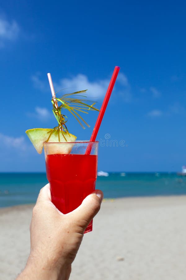 Coctailar på stranden i den manliga handen arkivfoto Coctailar på stranden i den manliga handen arkivfoto