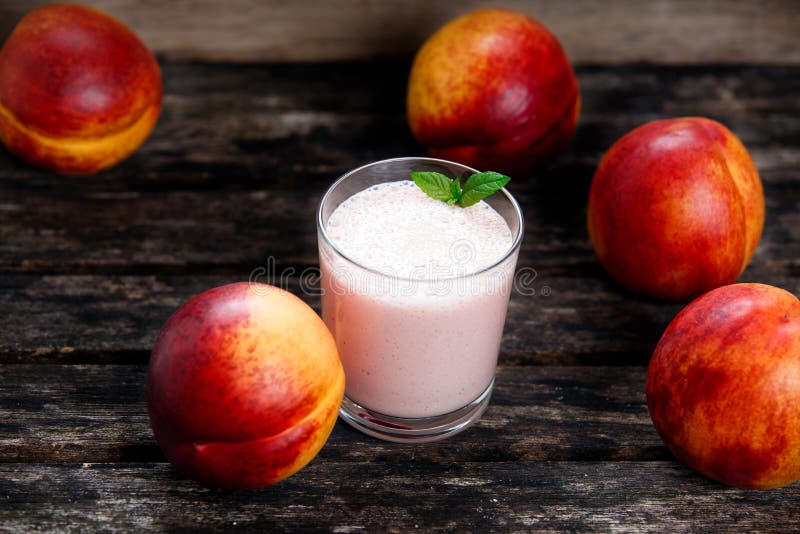 Coctailen från grekisk yoghurt och den nya saftiga nektarinen bär frukt close upp på den gamla trätabellen Bakgrund Utvalt fokuse arkivbild Coctailen från grekisk yoghurt och den nya saftiga nektarinen bär frukt close upp på den gamla trätabellen Bakgrund Utvalt fokuse arkivbild