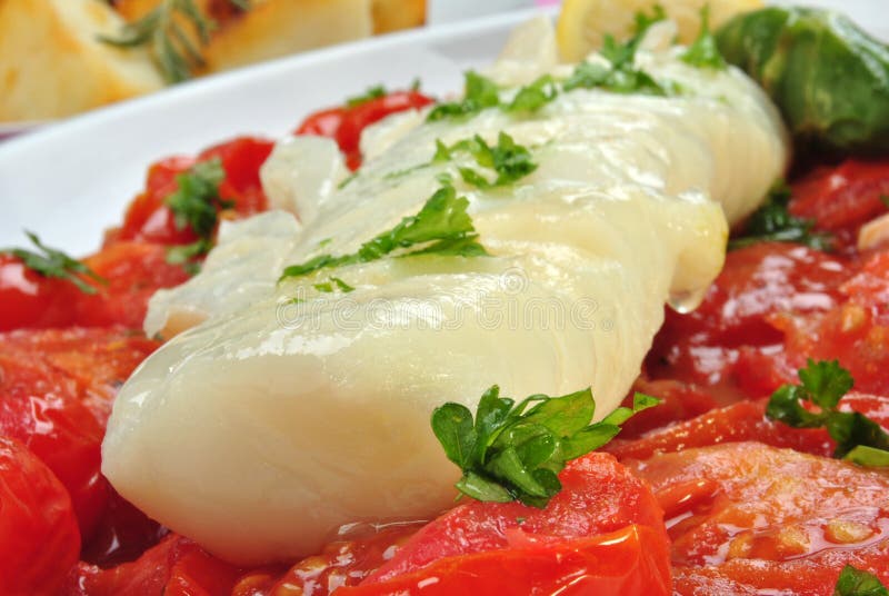 Cod loins with tomato on a plate