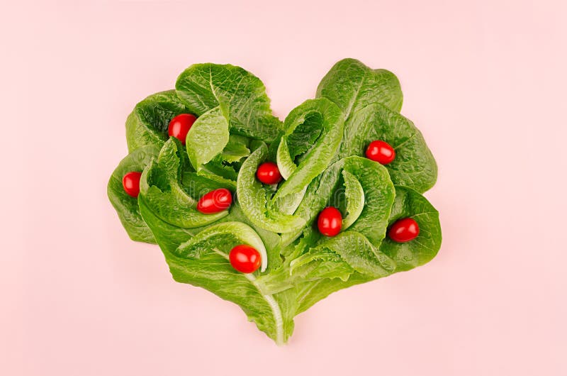 Coeur de nourriture saine de ressort - épinards de tomates-cerises et de feuilles sur le fond rose Contexte de jour du ` s de Val photo stock Coeur de nourriture saine de ressort - épinards de tomates-cerises et de feuilles sur le fond rose Contexte de jour du ` s de Val photo stock