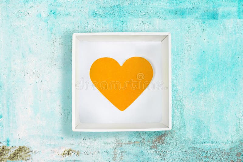 Coeur de papier jaune dans la boîte en carton blanche sur le vieux fond en métal de turquoise photographie stock Coeur de papier jaune dans la boîte en carton blanche sur le vieux fond en métal de turquoise photographie stock