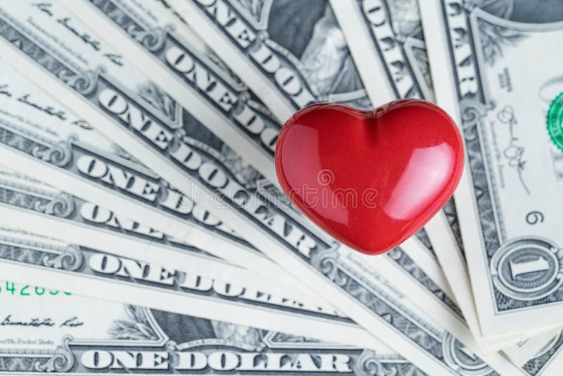 Coeur rouge brillant sur la pile des billets de banque de dollar US utilisant comme des affaires image libre de droits Coeur rouge brillant sur la pile des billets de banque de dollar US utilisant comme des affaires image libre de droits