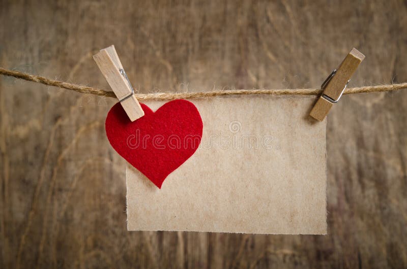 Coeur rouge de tissu avec la feuille de la pose de papier peint sur la corde à linge photographie stock libre de droits Coeur rouge de tissu avec la feuille de la pose de papier peint sur la corde à linge photographie stock libre de droits