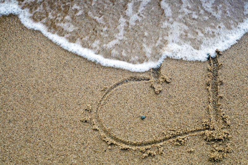 Disappearing heart drawn on the beach sand. Disappearing heart drawn on the beach sand.
