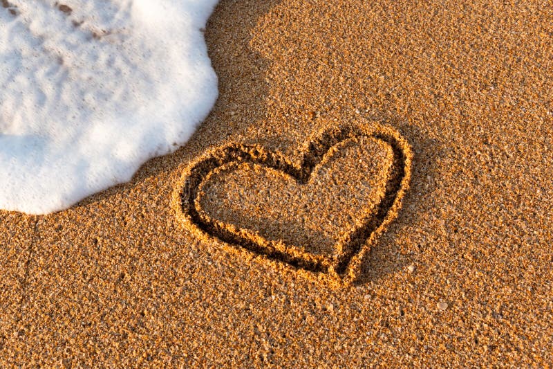 Heart drawn in the sand on the beach at sunset. Heart shape. Heart symbol. Love. Sea foam. Heart drawn in the sand on the beach at sunset. Heart shape. Heart symbol. Love. Sea foam.