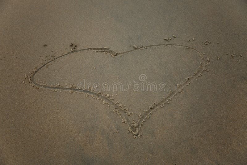 Drawn heart on wet sea sand. Love and tenderness at the resort. Close-up. Drawn heart on wet sea sand. Love and tenderness at the resort. Close-up.