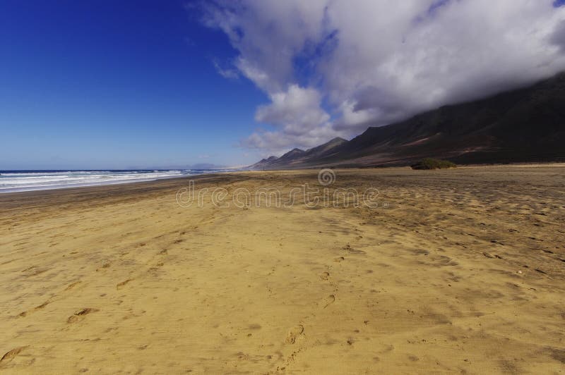 Cofete beach and dark volcanic mountains stock images