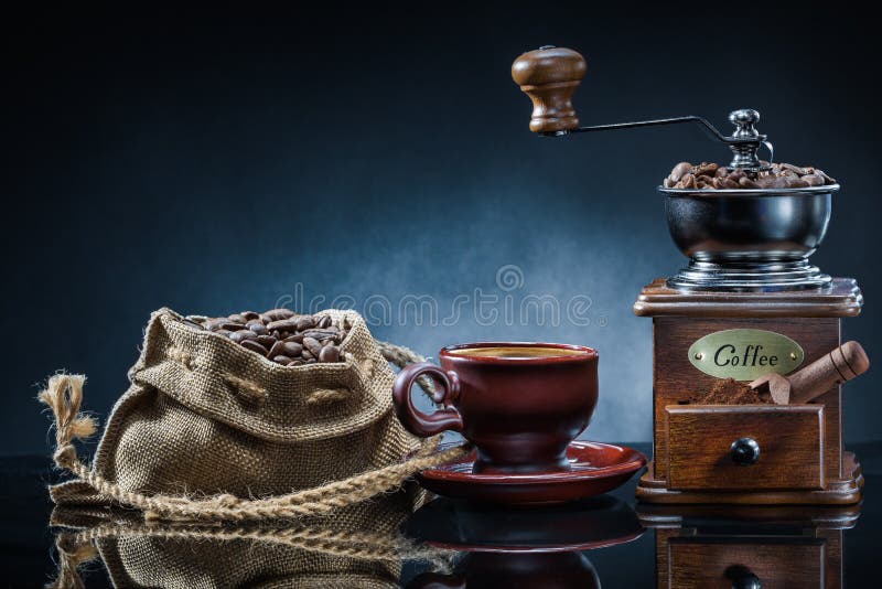 Coffe maler koppen och säcken med bönor på spegeltabellen fotografering för bildbyråer Coffe maler koppen och säcken med bönor på spegeltabellen fotografering för bildbyråer