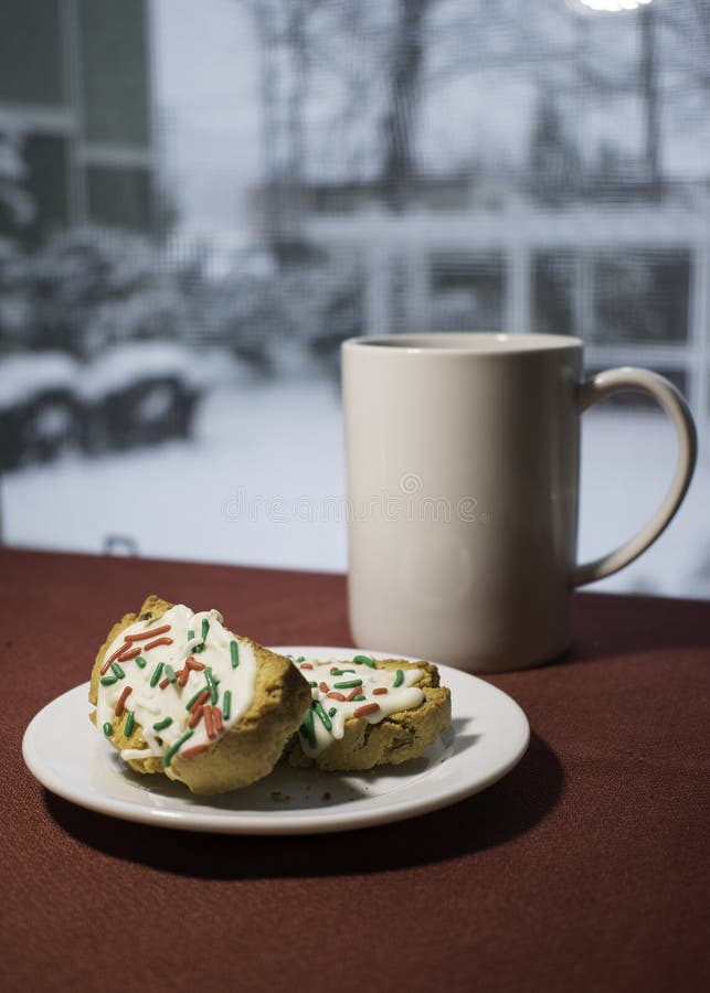 Coffe och Biscotti framme av fönstret på snöig dag fotografering för bildbyråer Coffe och Biscotti framme av fönstret på snöig dag fotografering för bildbyråer