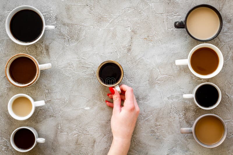Coffee Addiction. Mug in Hand, Many Cups on Grey Desk Topdown Stock