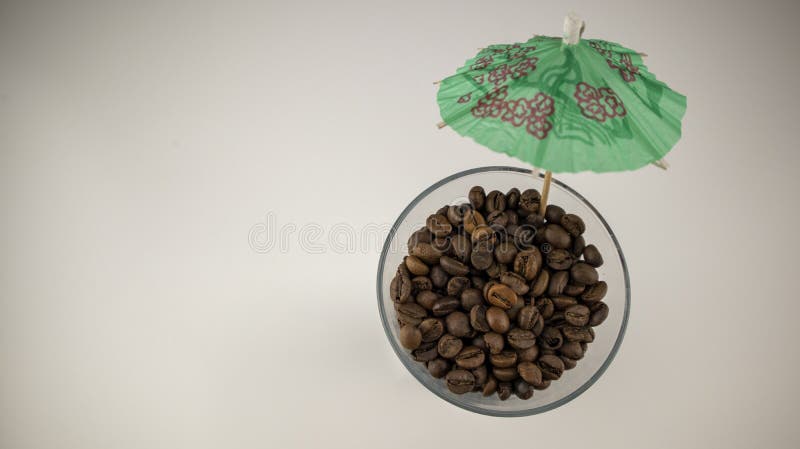Coffee beans in a glass with a cocktail umbrella stock photography Coffee beans in a glass with a cocktail umbrella stock photography