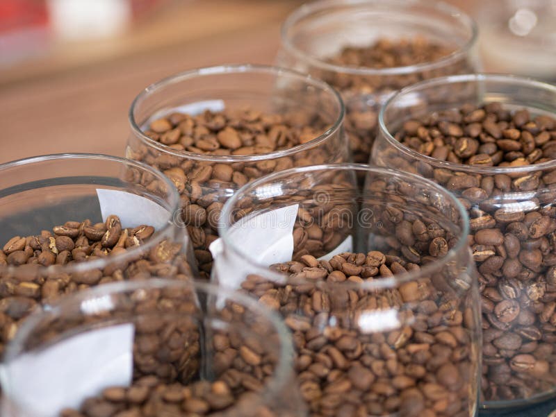 Coffee Beans in Glass Jars Standing in Rows on a Store Shelf Stock