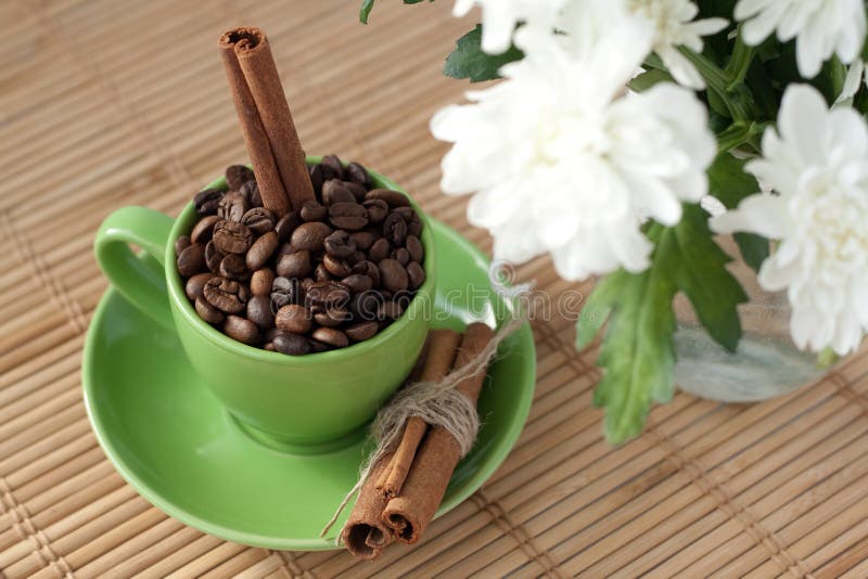 Coffee beans in a green cup