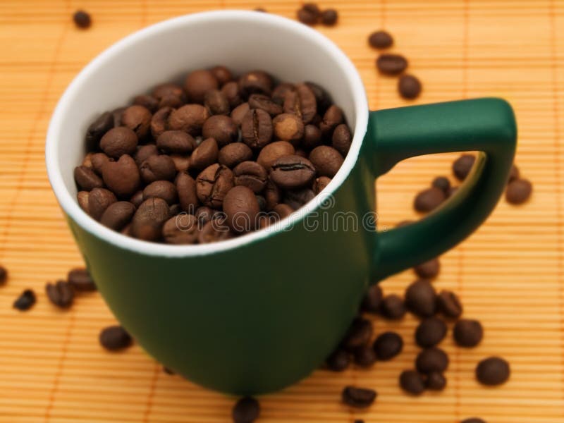 Coffee beans in a green cup