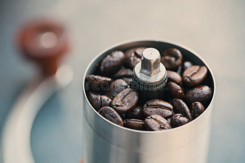 Coffee Beans in a Hand Grinder, Closeup Roasted Coffee Beans into a