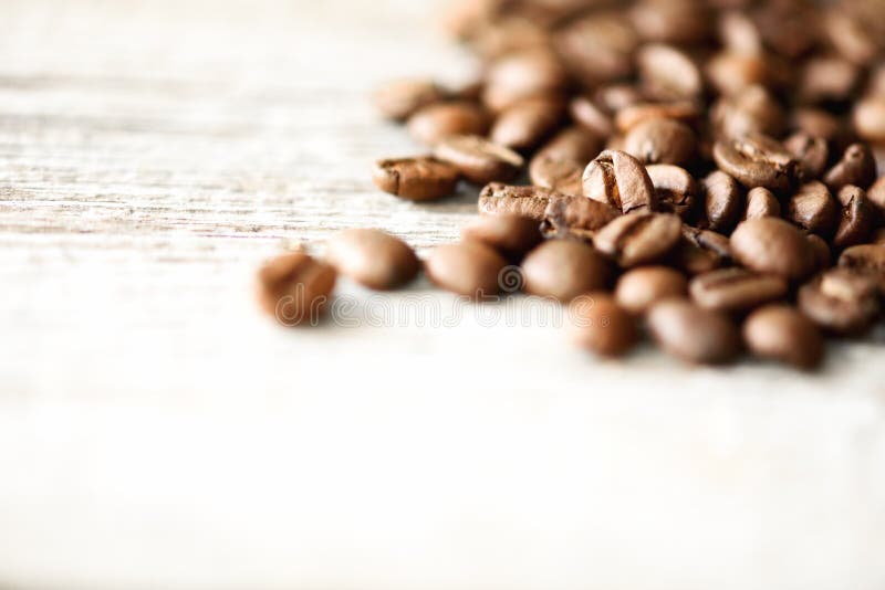 Coffee beans on light wooden background with copyspace for text. Coffee background, food frame, texture concept. Banner. Coffeeshop, cafe.