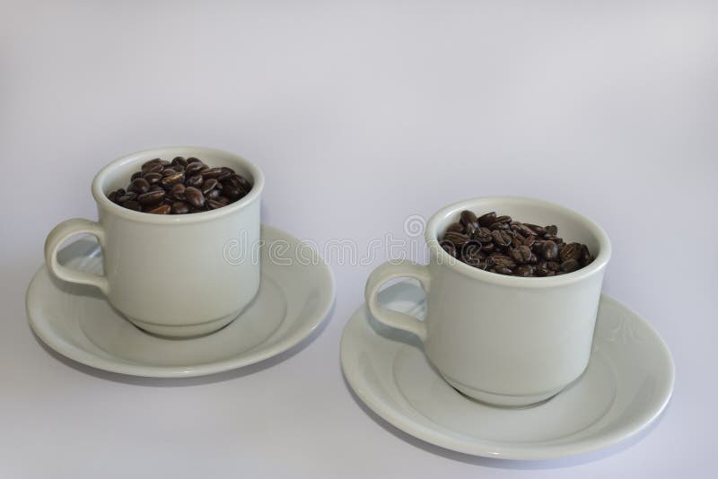 Coffee Beans in Two Coffee Cups , on White Isolated Background Stock