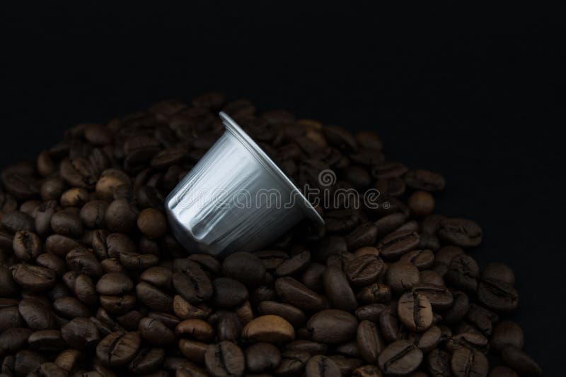 Coffee Capsules or Coffee Pods on Coffee Beans, Black Background