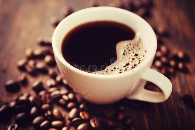 Tazza di caffè e fagioli, sul tavolo di legno.