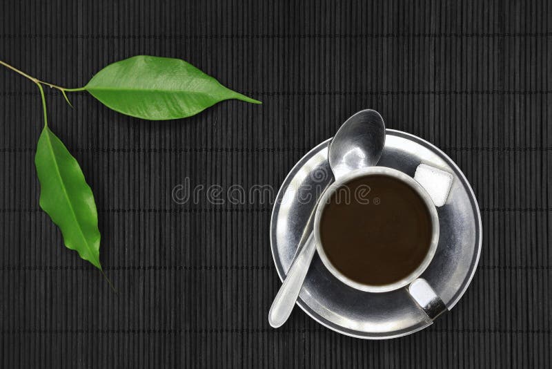 Coffee cup on black wood, with spoon, sugar and plants. Coffee cup on black wood, with spoon, sugar and plants