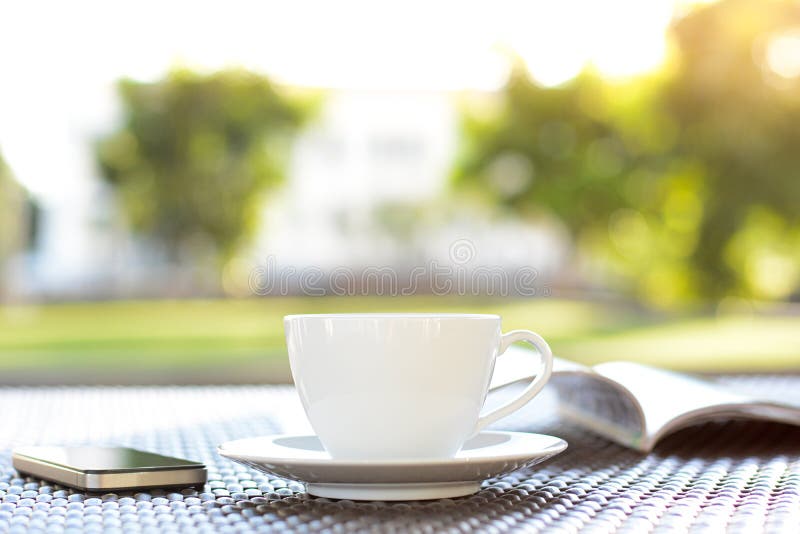 Coffee cup with book on blurred green nature background stock image Coffee cup with book on blurred green nature background stock image