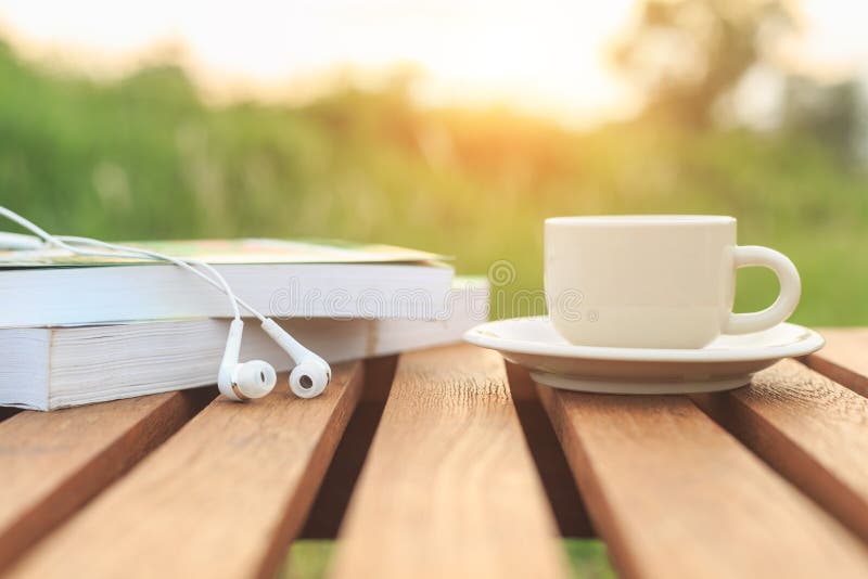 Café taza a un libro sobre el mesa en manana.