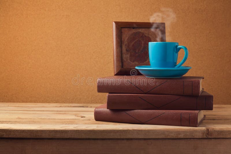 Coffee cup and books on wooden vintage table over retro background