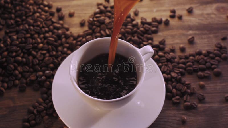Cup of hot coffee on a dark background with coffee beans. Hot cafe video