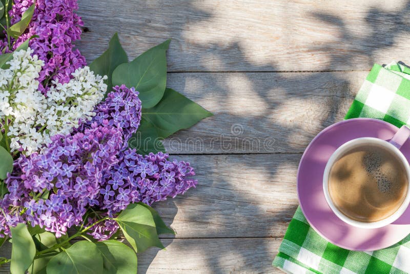 Coffee cup and colorful lilac flowers on garden table royalty free stock photos Coffee cup and colorful lilac flowers on garden table royalty free stock photos