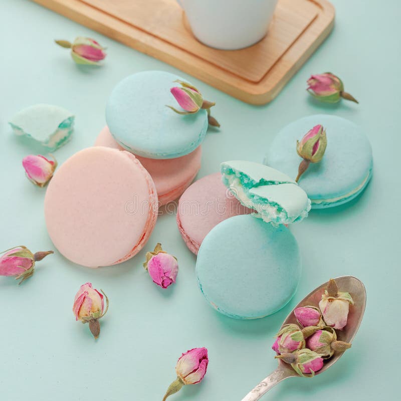Coffee cup and colorful macaron on pastel background top view.