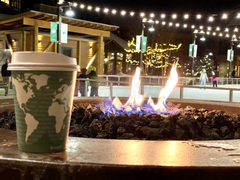 Coffee cup in front of  fire rink at ski resort