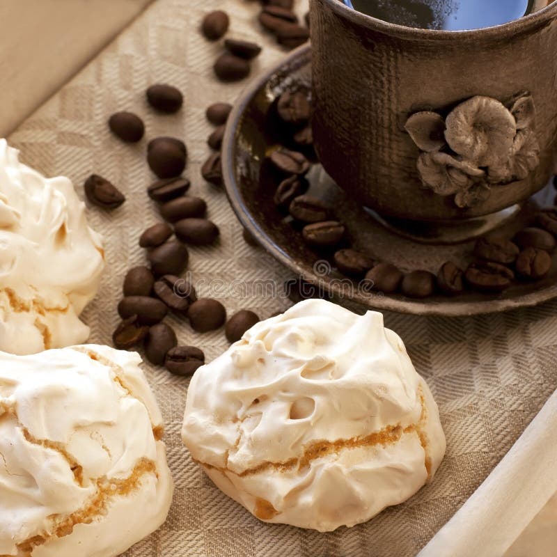 Coffee cup with meringues on table