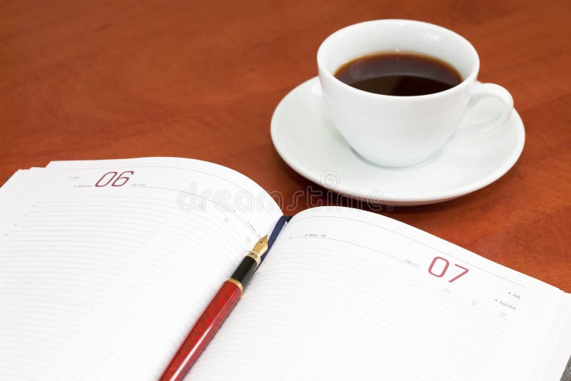 Coffee cup, notebook and pen