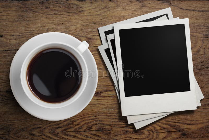 Coffee cup and polaroid photo frames on table