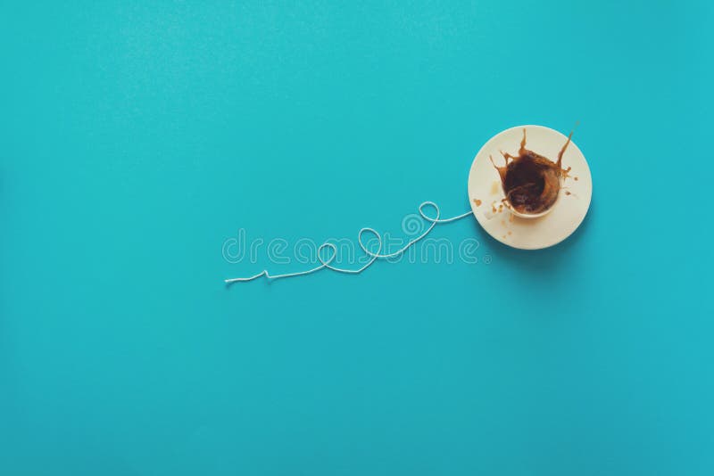 Coffee Cup in Shape of Balloon with Clouds on Blue Paper Background