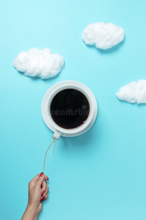 Coffee Cup in Shape of Balloon with Cotton Clouds on Pastel Blue