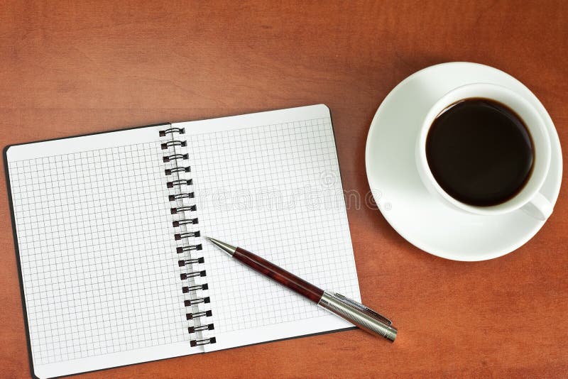 Coffee cup, spiral notebook and pen