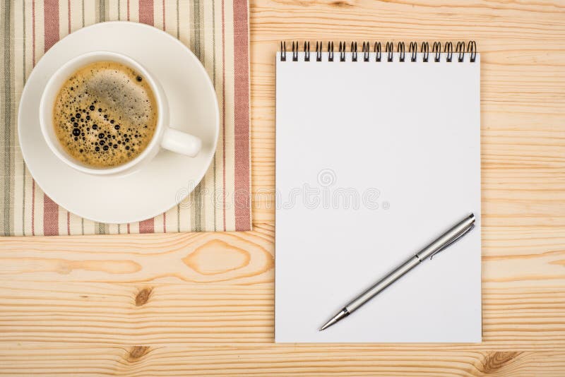 Coffee cup, spiral notebook and pen