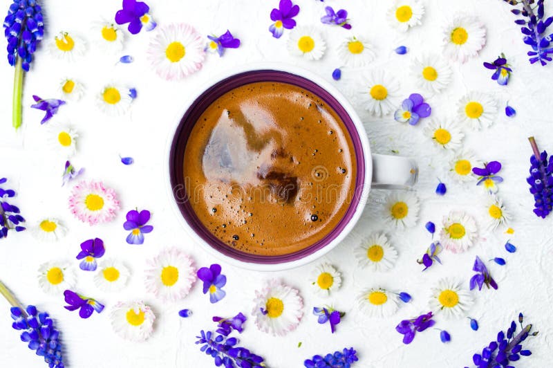 Coffee cup and spring flowers on white background flat lay