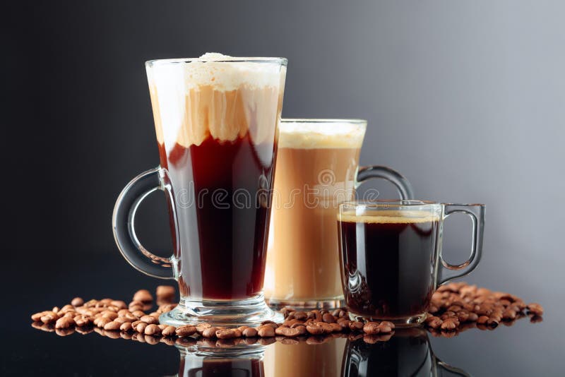 latte macchiato and cappuccino with glass cup and mug on a mirrored black  background, space for text Photos