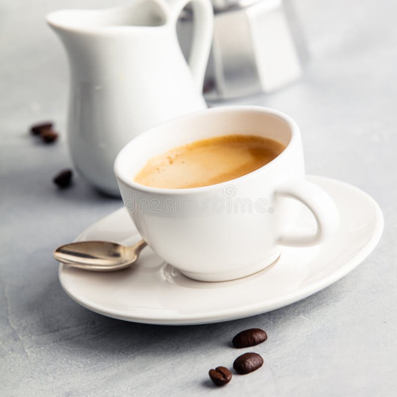Coffee Espresso in White Cup with Milk and Coffee Maker Stock Photo