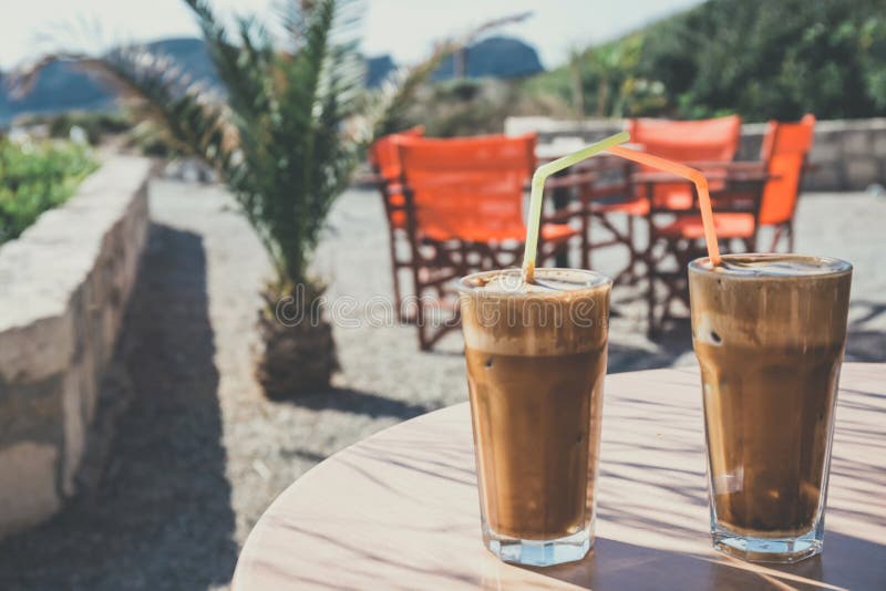 Coffee frappe, greek cuisine on the table at the beach