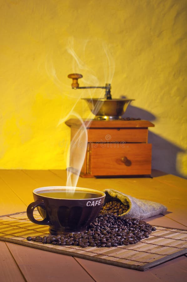 A coffee grinder and cup of coffee