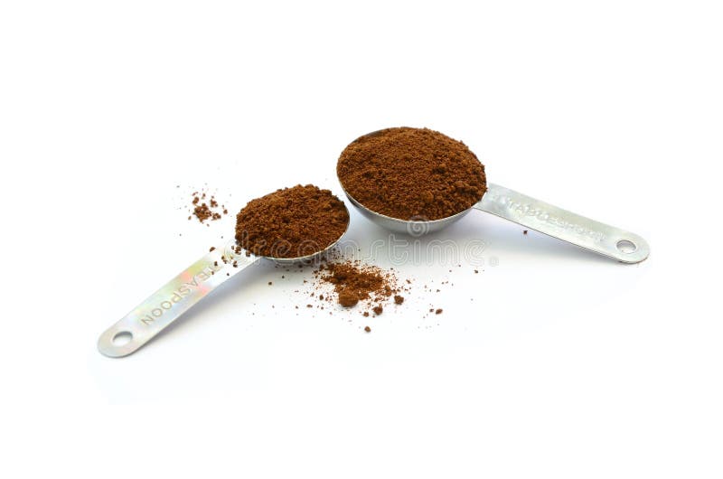 Coffee ground in stainless table and tea spoon isolated in white background