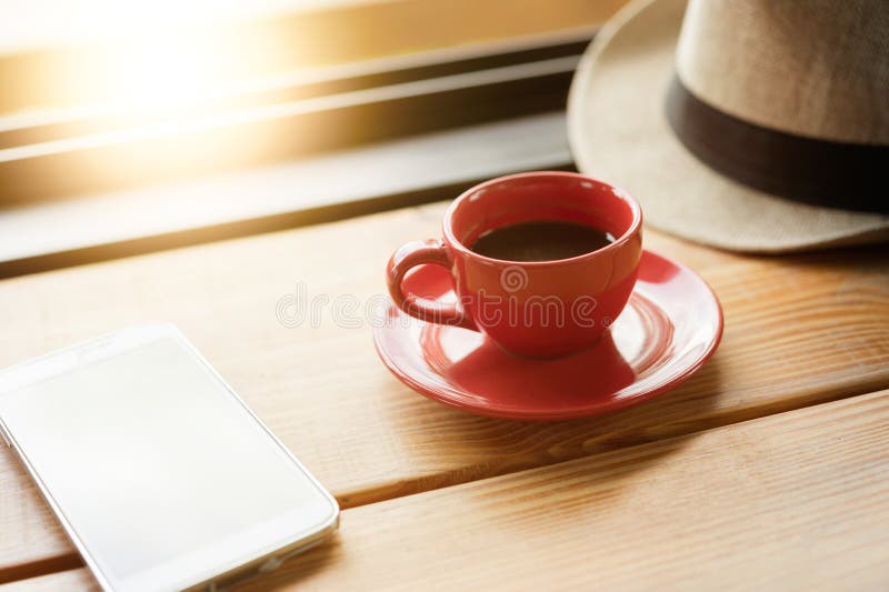 Coffee with Hat and Smart Phone on Coffee Shop Table Stock Image